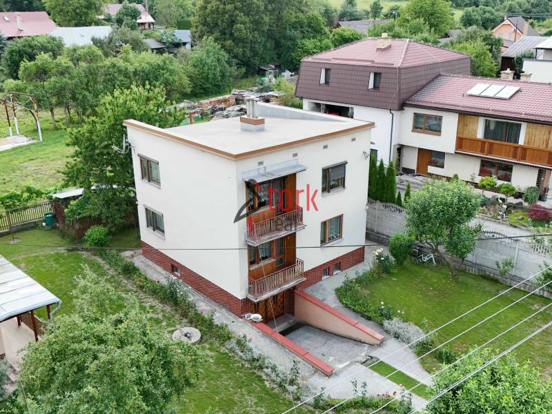 A family house in Dolná Mariková surrounded by greenery and neighboring houses in a peaceful environment.