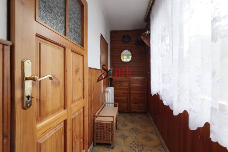 Interior of a family house with wooden doors and a glazed interior with decorative curtains.