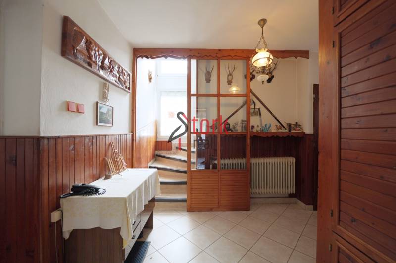 A hallway in a family house with wooden paneling and decorations on the walls.