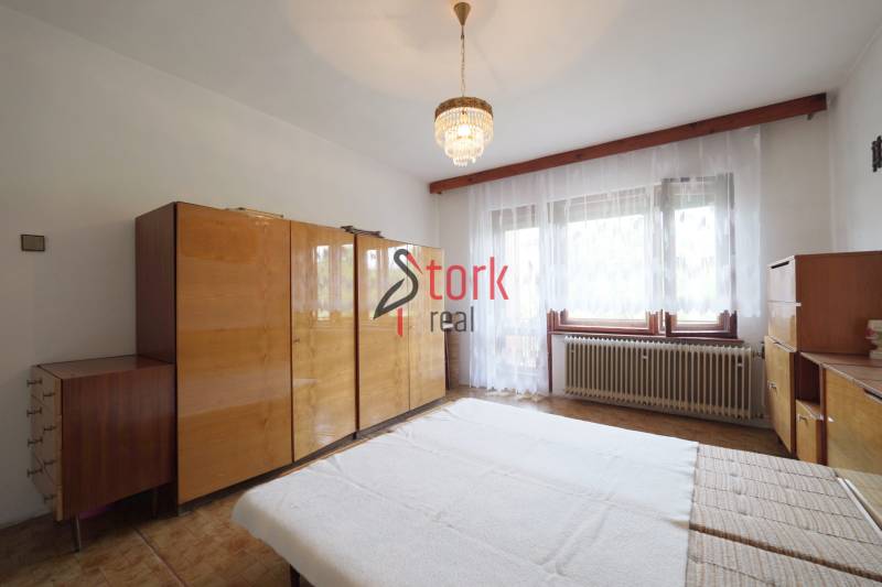 A bedroom with wooden furniture and a chandelier in a family house, a bright room.