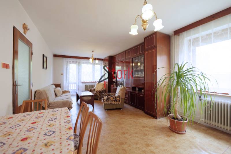 Living room in a family house with a carpeted floral table and wooden furniture.