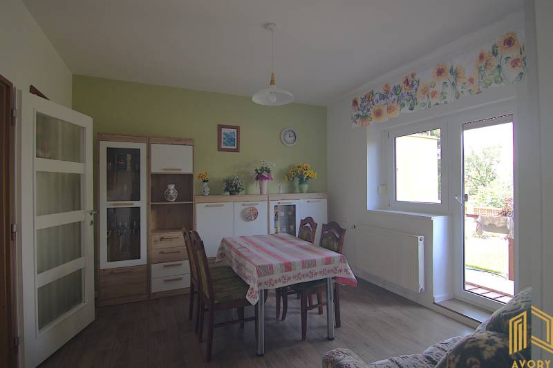 Dining room in a family house with a table, chairs, and a cabinet with decorations.