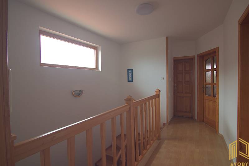 Wooden staircase with a window and doors in a family house, interior space.