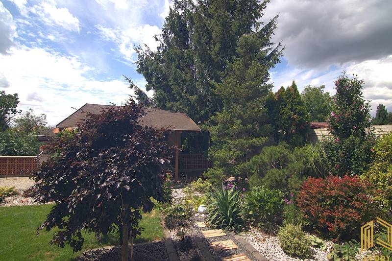 Garden area with a gazebo and diverse vegetation at a family house on Športová Street in Brodské.