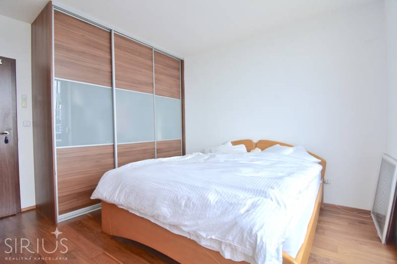 Bedroom with a large built-in wardrobe and bed in a 4-room apartment.