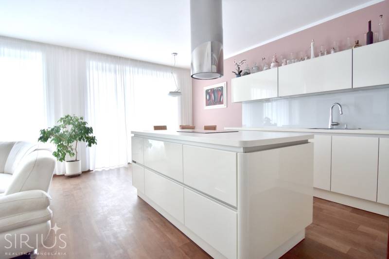 A bright kitchen with an island in a 4-room apartment with built-in cabinets and wooden flooring.