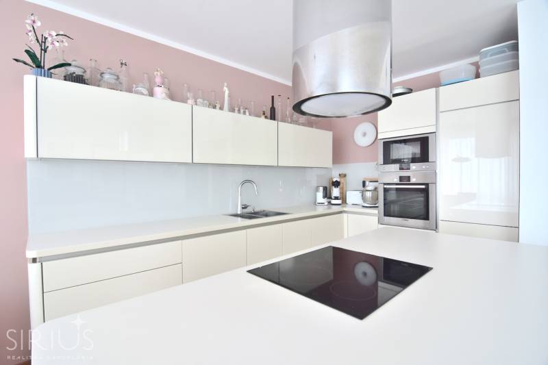 A kitchen in a 4-room apartment with white cabinets and built-in appliances.