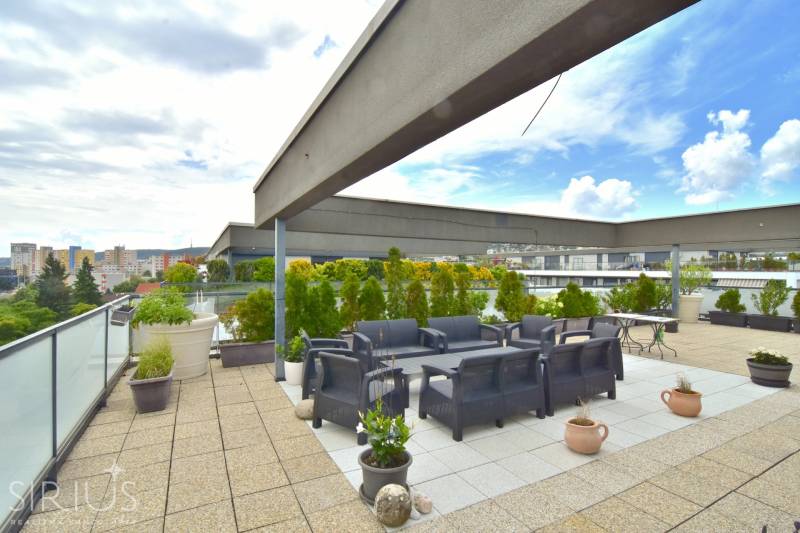 Rooftop terrace of a 4-room apartment on Pri vinohradoch, Bratislava - Rača, with seating and greenery.