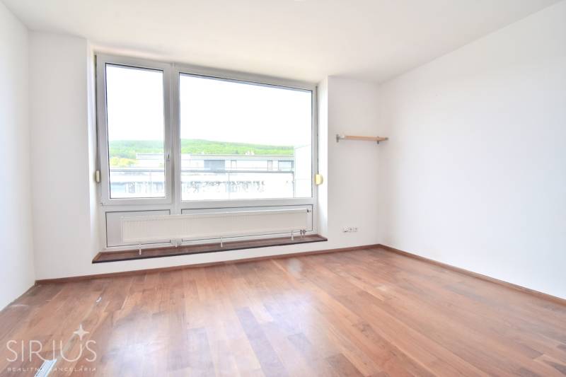 An empty room with a large window and wooden floor in a 4-room apartment.
