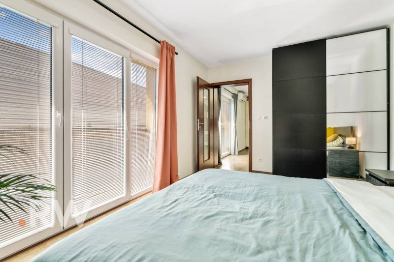 Bedroom in a 3-room apartment with a wardrobe, windows, and curtains.