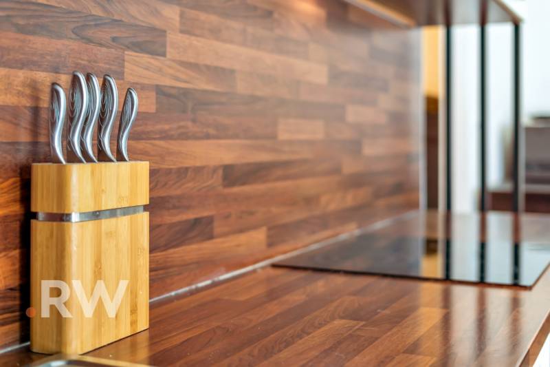 A wooden kitchen counter with knives in a 3-room apartment.