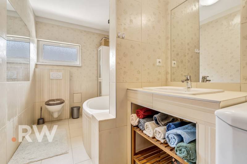 A bathroom with a bathtub, sink, and towels suitable for a 3-room apartment.