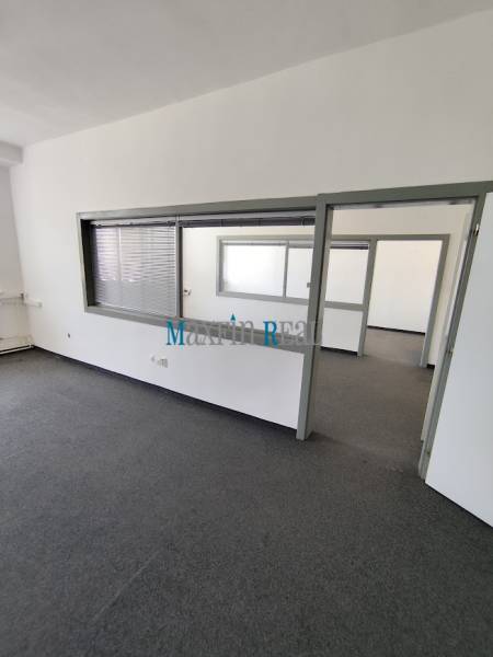 Interior view of empty offices with glass partitions and carpet.
