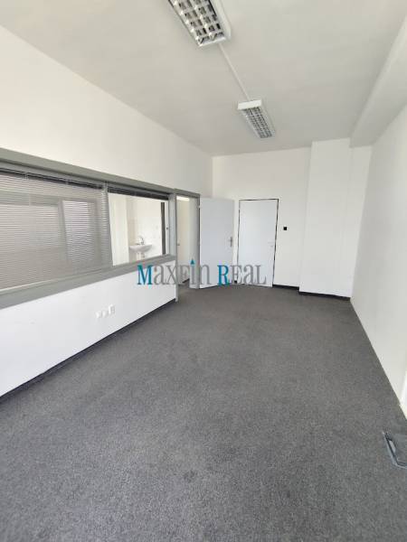 Offices with carpet, white walls, and two entrances for maximum functionality.