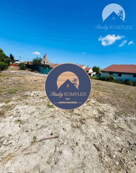Plots - living in Veľký Meder, with a view of the blue sky and rooftops.