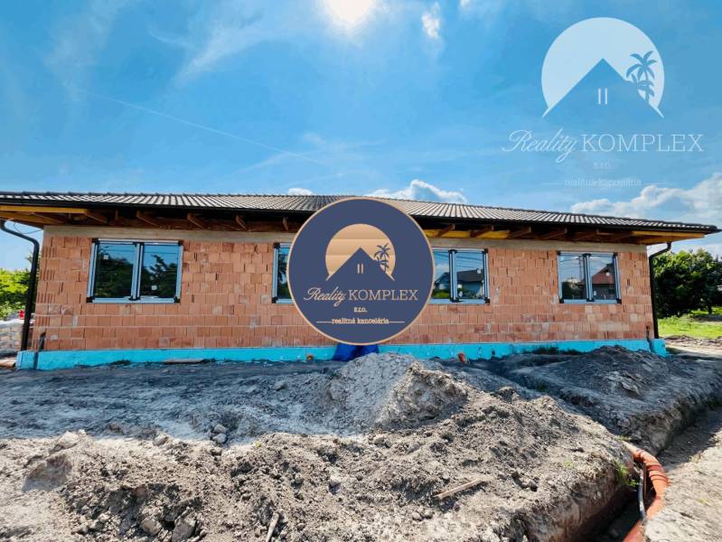 A family house under construction in Veľký Meder with brick walls and a roof.