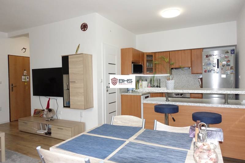 Kitchen and living room in a 3-room apartment, furnished interior with wooden furniture.