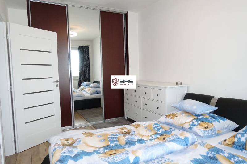 Bedroom in a 3-room apartment with a bed and built-in wardrobe, light walls and a dresser.