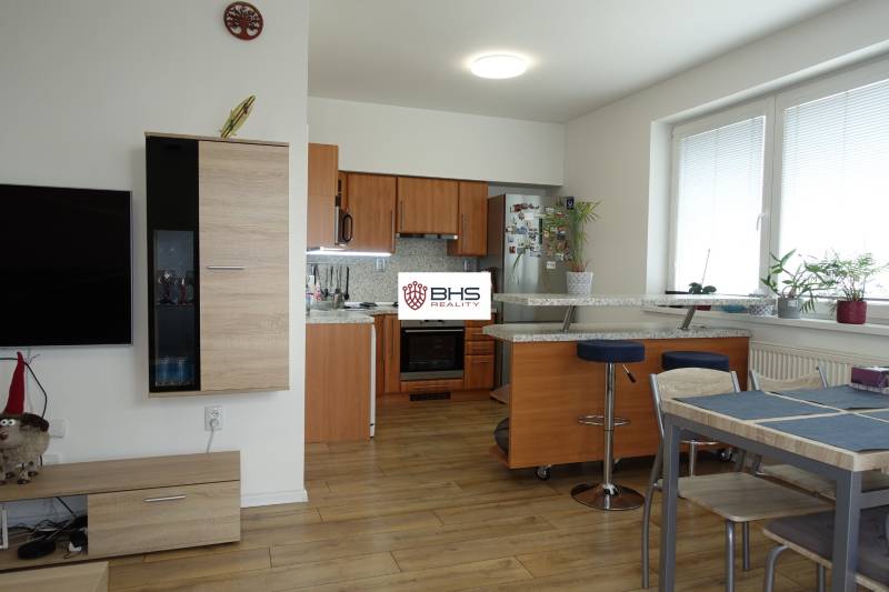 A kitchen with a bar counter and a dining table in a 3-room apartment.