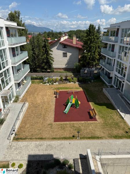 The courtyard between apartment buildings on Hurbanova Street in Poprad with a children's playground and benches.