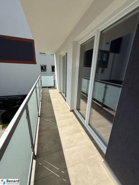 A balcony with tiles and sliding glass doors in a 3-room apartment on Hurbanova Street in Poprad.