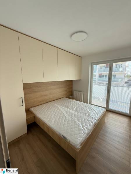 Bedroom in a 3-room apartment with a bed, wardrobe, and large window.