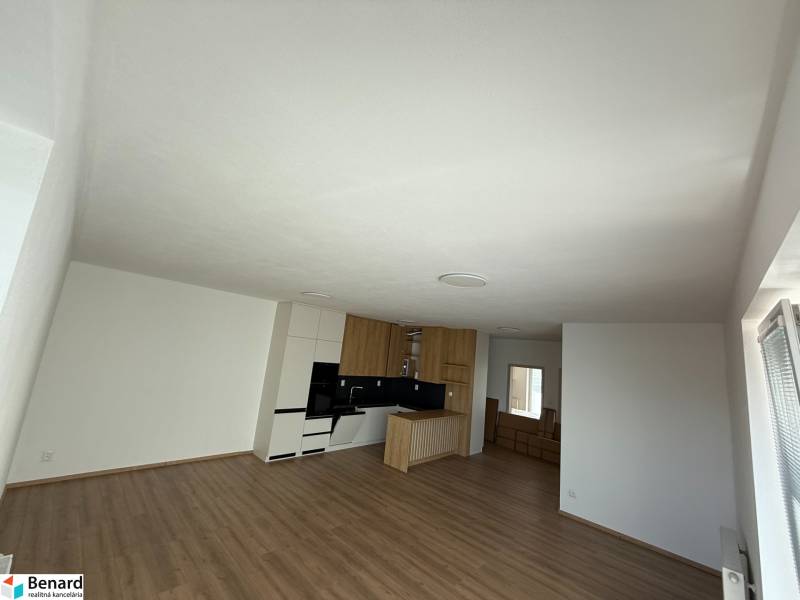 Bright open space with a kitchen and wooden floor in a 3-room apartment.