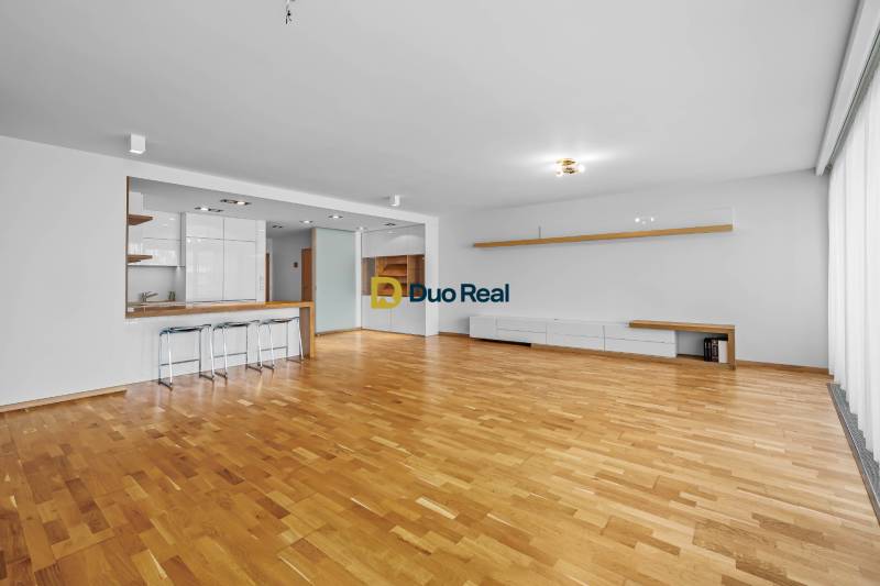 A spacious living room with a bar counter and wooden flooring, 3-room apartment.