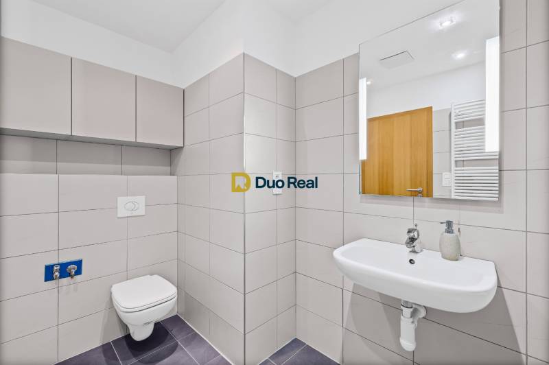 A bathroom with a wall-hung toilet and sink in a 3-room apartment.