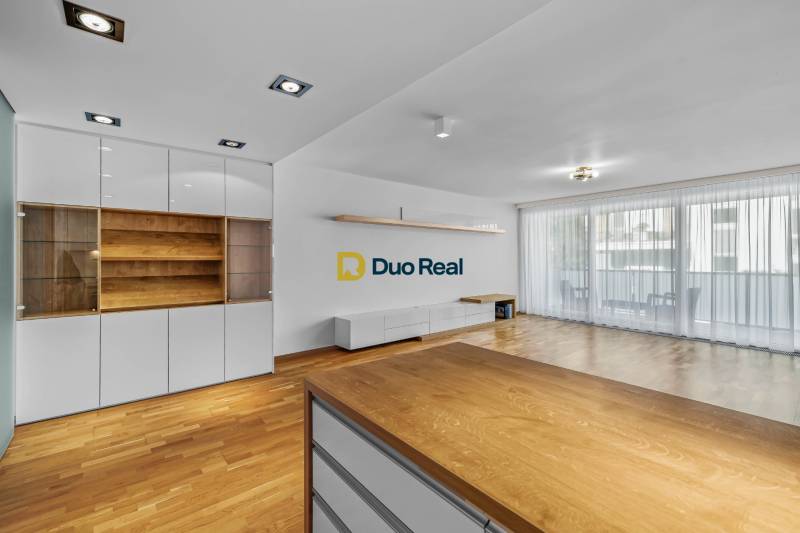 A living room in a three-room apartment with wooden flooring and built-in wardrobes.