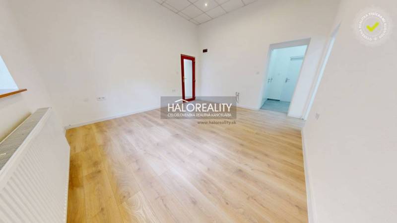 An office interior with a light floor and white walls, ready to be furnished.