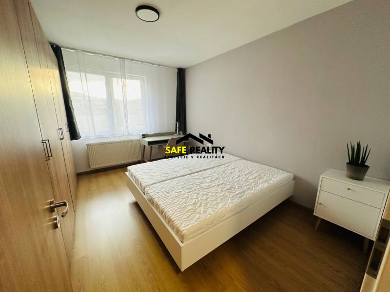 Bedroom in a 2-room apartment with a double bed, wardrobe, and nightstand.