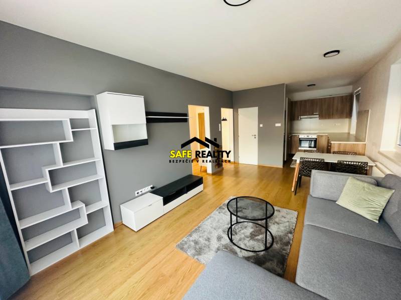 Living room in a two-room apartment with a sofa, dining table, and kitchenette.