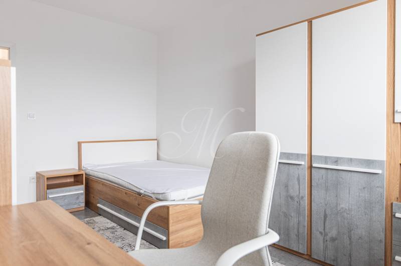 A bedroom with a bed, a cabinet, and a wardrobe in a three-room apartment.