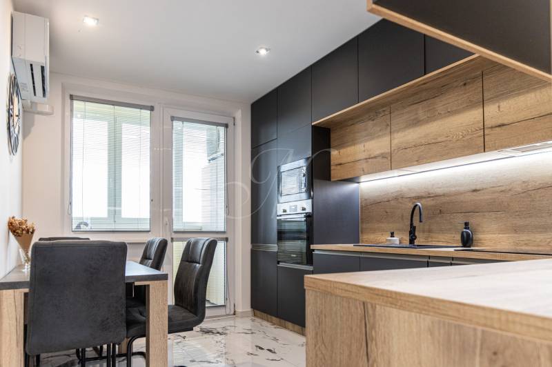 A kitchen with wooden elements and a modern dining table in a 3-room apartment.