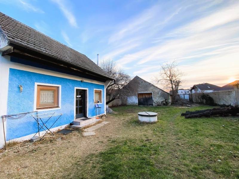 Blue house with a yard and garage on Breitegasse in Illmitz, planned construction of apartments.