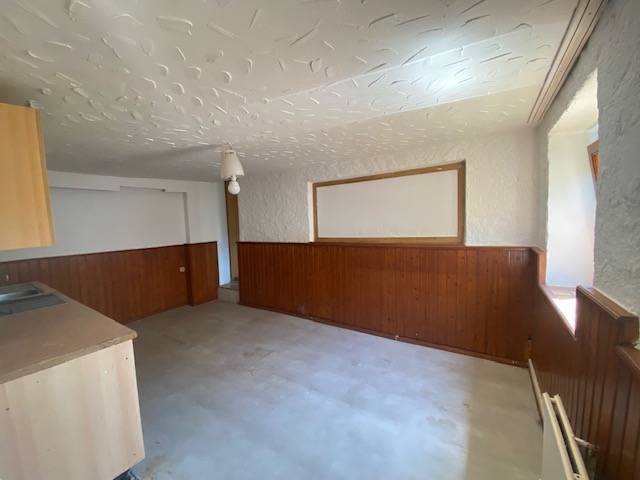 Interior of a room with wooden paneling and a kitchenette. Apartment construction.