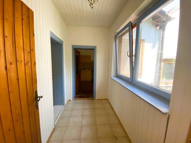 A narrow corridor with light walls and wooden doors in an apartment building under construction.