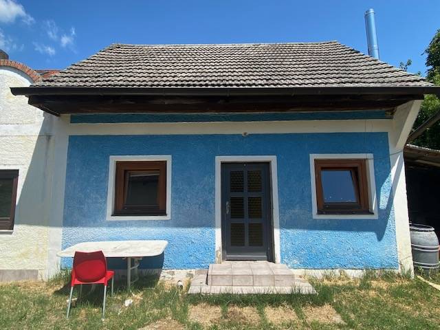 Blue house with a sloped roof on Breitegasse in Illmitz, apartment construction.