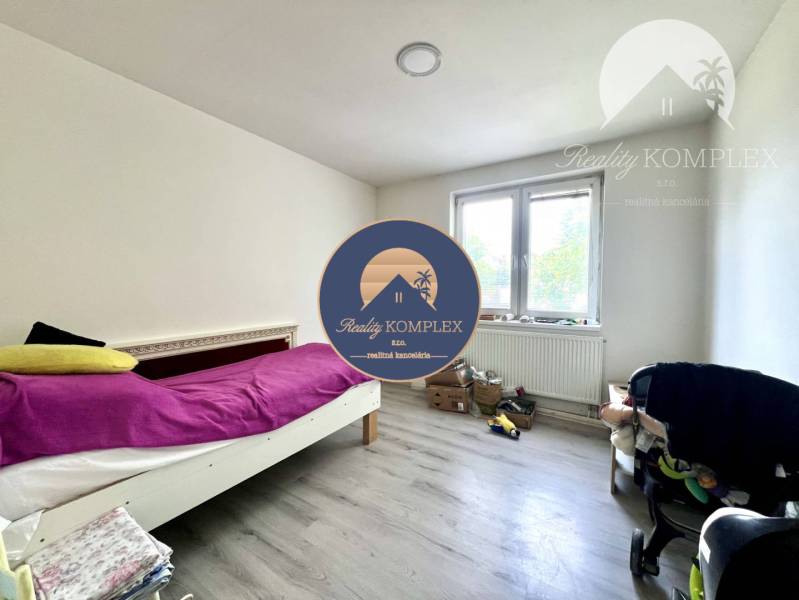 A room in a family house with a single bed and a large window.