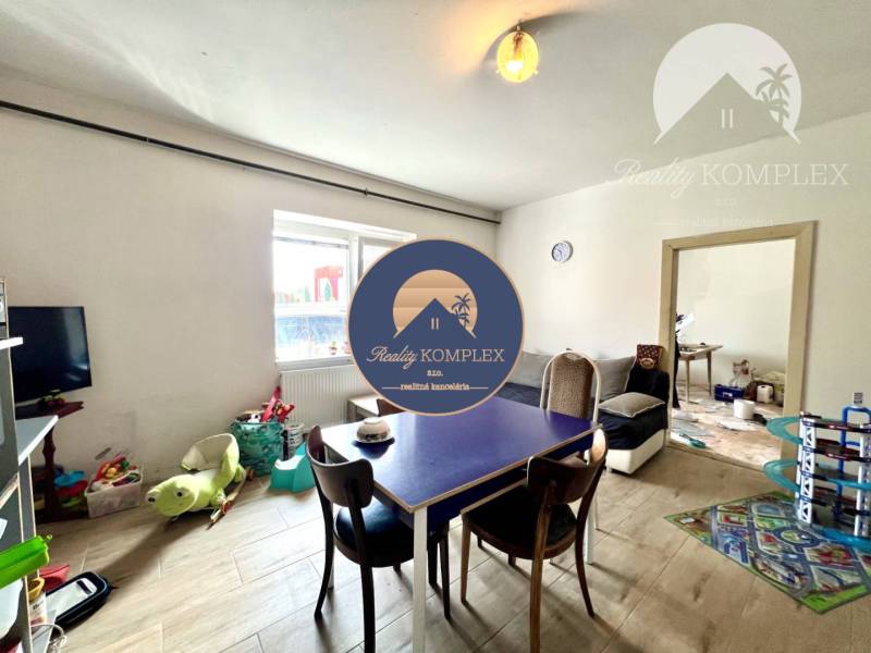 Interior of a family house with a dining table, toys, and a television.