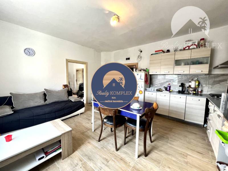 Living room with kitchen in a family house, comfortable sofa, wooden table, white sideboard.