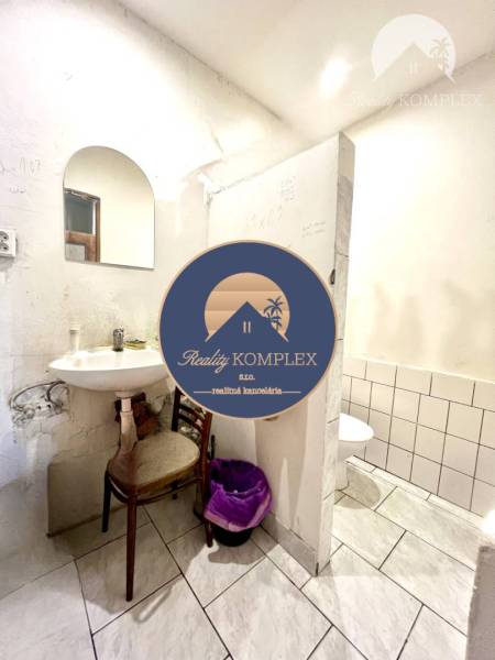 Bathroom in a family house with a mirror, sink, and toilet.