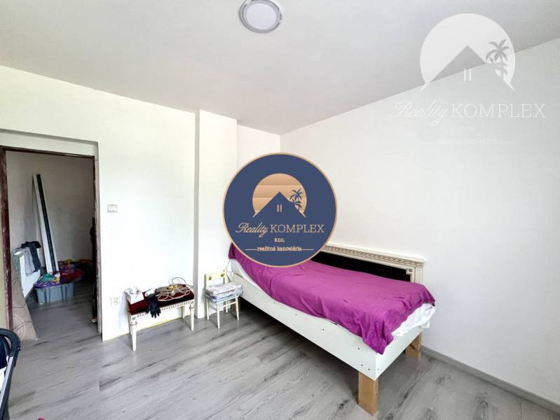 A bedroom with a single bed, wooden floor, minimalist furnishings of a family house.