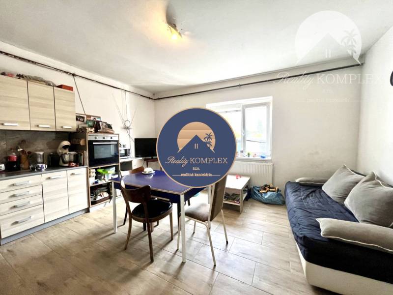 Living room in a family house with a kitchenette, sofa, and dining table.