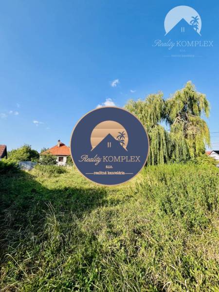 Plots - housing in Moča, Okoč with a view of the grassy area and houses in the background.