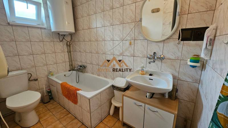 Bathroom in a family house with a bathtub, sink, and toilet.