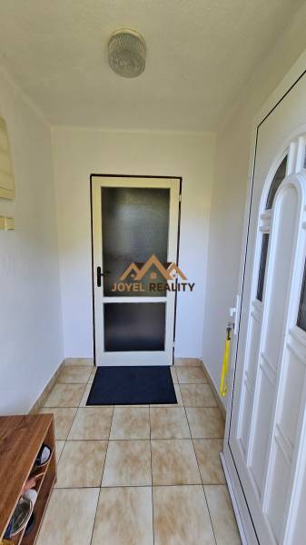 Entrance hallway in a family house with tiles and white doors.