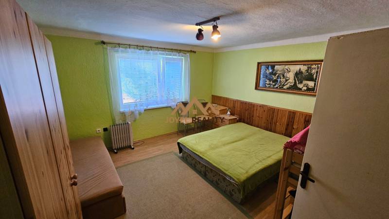 Bedroom in a family house with a bed, wardrobe, and a picture on the wall.