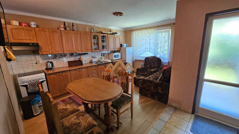 A kitchen in a family house with a wooden cabinet and a dining table.